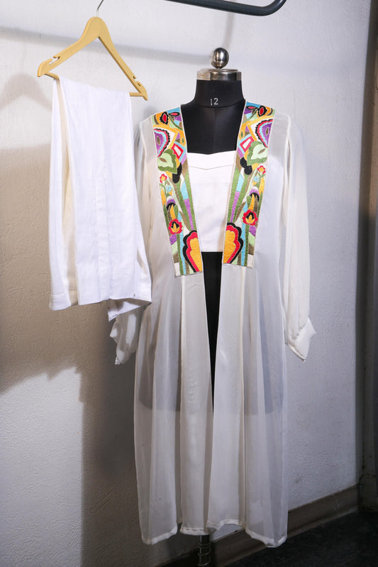 "Embroidered Elegance: A White Georgette Cape Blooms with Colorful Threads"